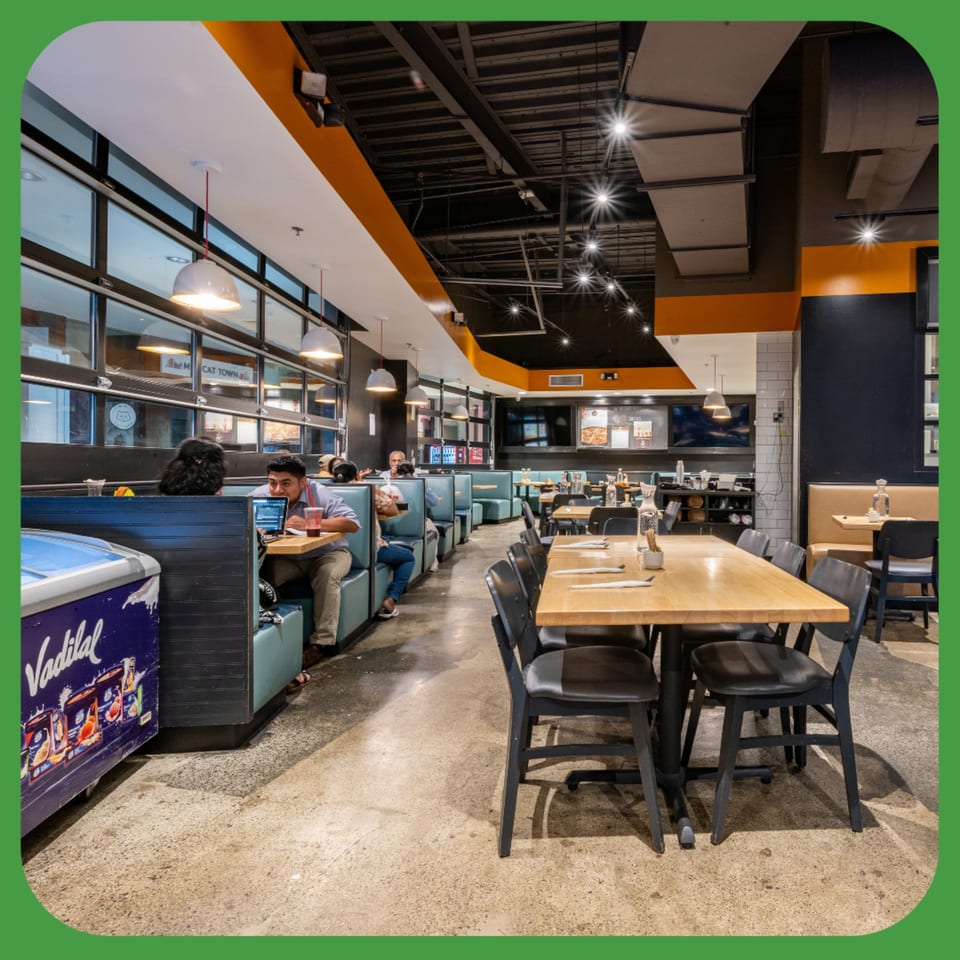 ID Cafe's spacious dining area with booths, tables, and customers, featuring modern industrial design.